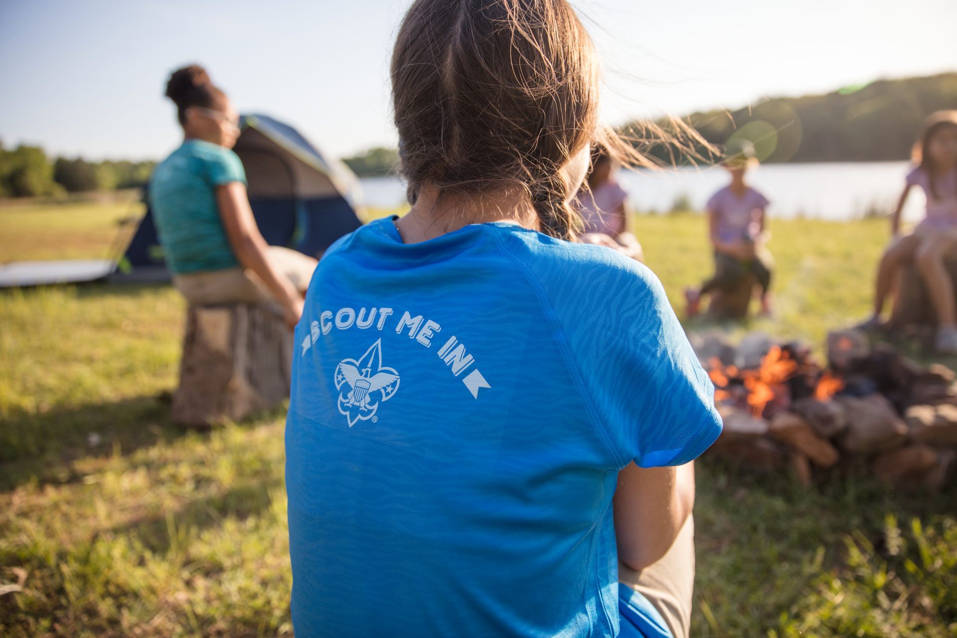 Scouts around the campfire circle at dusk